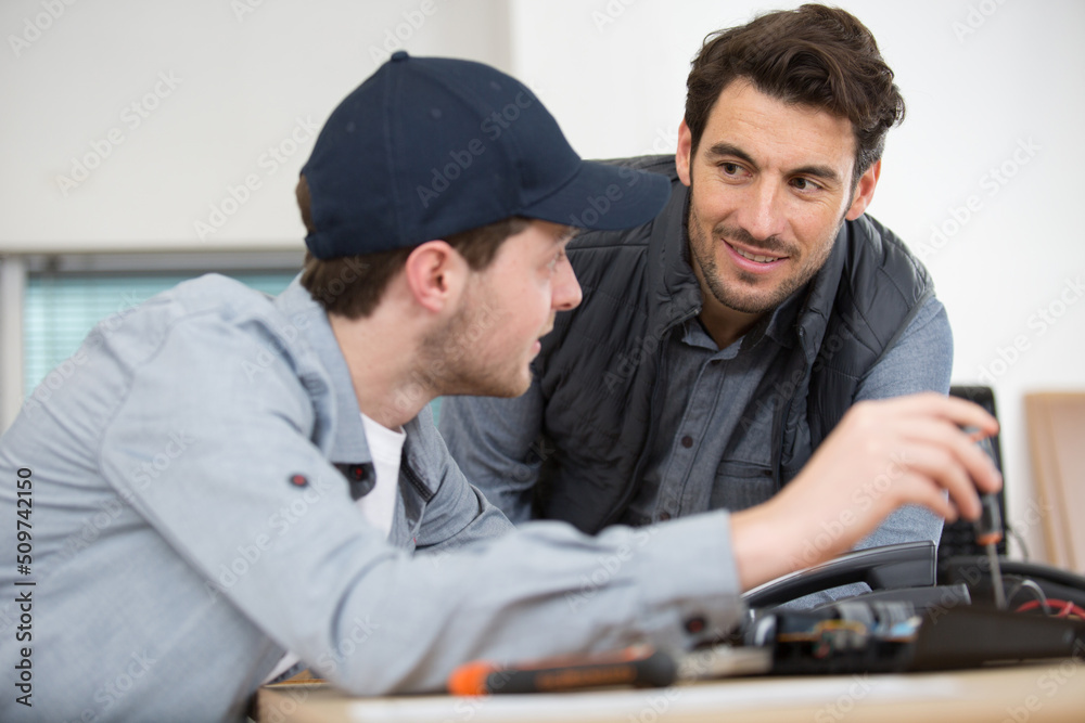 apprentice technician repairing telephone handset apprentice technician repairing telephone handset