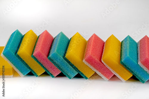 Colorful sponges with an abrasive bright white layer for washing dishes and other household or domestic needs.