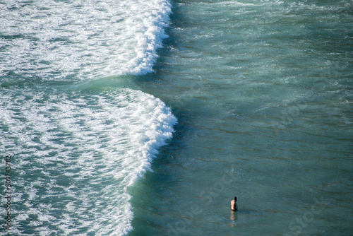 View of tourist bathing near dangerous rip current at Piha beach, Auckland, New Zealand. Copy space stock photo. photo