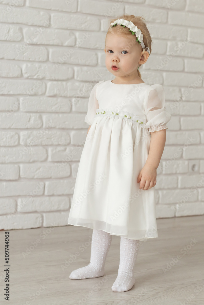 Baby child with hearing aids and cochlear implants on white brick wall. Deaf and health and diversity concept Baby child with hearing aids and cochlear implants on white brick wall. Deaf and health and diversity concept