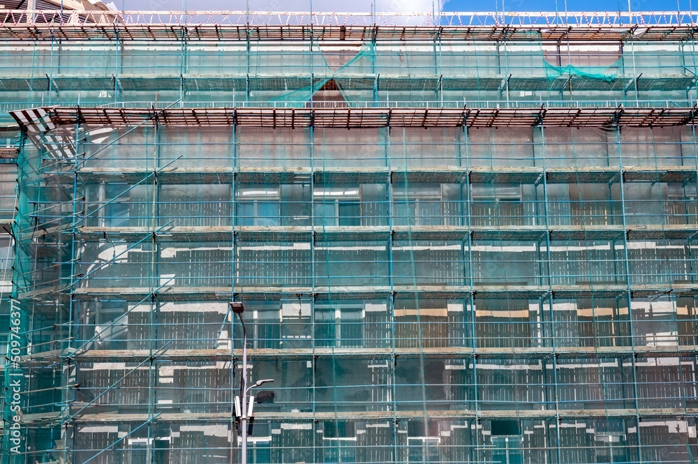 A large building that is under construction and is surrounded by scaffolding - special bridges for moving people on the site. A large building that is under construction and is surrounded by scaffolding - special bridges for moving people on the site.