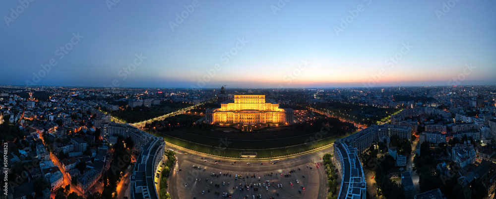 Aerial drone panoramic view of Palace of the Parliament in Bucharest downtown at night, Romania