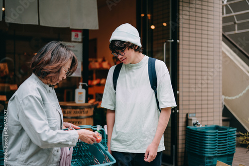 八百屋で買い物をする祖母とハーフの10代の息子