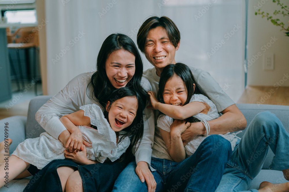 ソファに座って笑う日本人家族