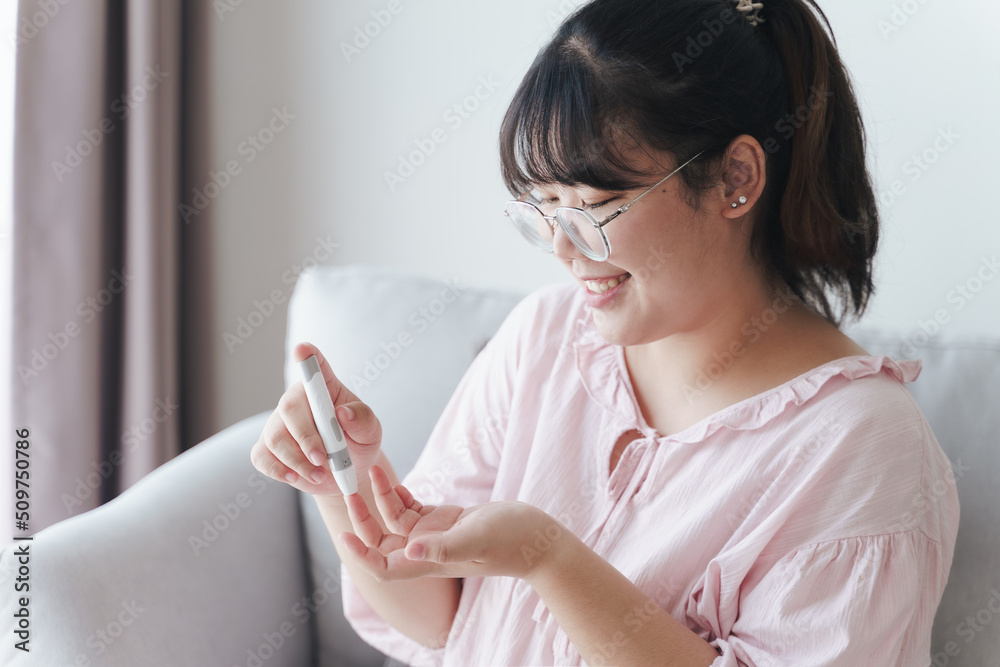 Asian woman using lancet on finger for checking blood sugar level by Glucose meter, Healthcare and Medical, diabetes, glycemia concept Asian woman using lancet on finger for checking blood sugar level by Glucose meter, Healthcare and Medical, diabetes, glycemia concept