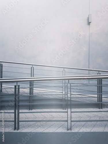 A rough concrete ramp way with stainless steel handrail to support wheelchair disabled people. A ramp way for pushcart load to entrance or exit a building.