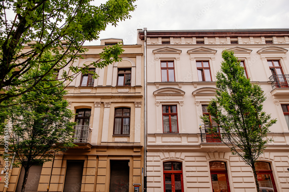 Fototapeta premium odnowione kamienice wśród drzew