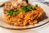 Bowl of east African Jollof Rice garnished with pieces of roasted chicken