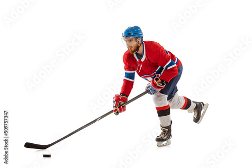 Young male hockey player in sports uniform and protective equipment training isolated on white background. Concept of sport, healthy lifestyle, motion, movement, action.