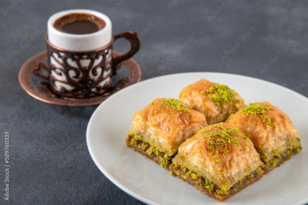 Pistachio baklava on a white plate with Turkish coffee Pistachio baklava on a white plate with Turkish coffee