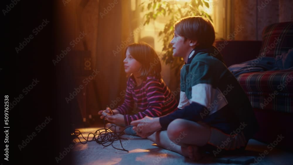 Nostalgic Childhood Concept: Young Brother and Sister Playing Old-School Arcade Video Game on a Retro TV Set in a Living Room with Period-Correct Interior. Friends Spend the Day at Home Playing Games.