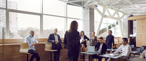 canvas print motiv - Studio Romantic : Various businessmen listen to female business leader during corporate meeting or training lecture. Rear view of woman in business attire speaking to people in modern business center. Panoramic view.