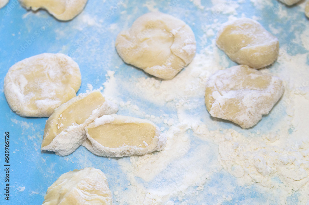 pieces of dough in flour on a blue background