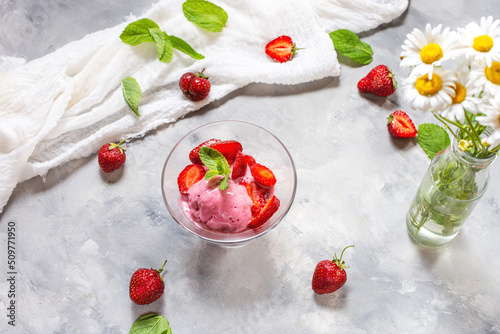 Homemade strawberry ice cream decorated with fresh berries and mint