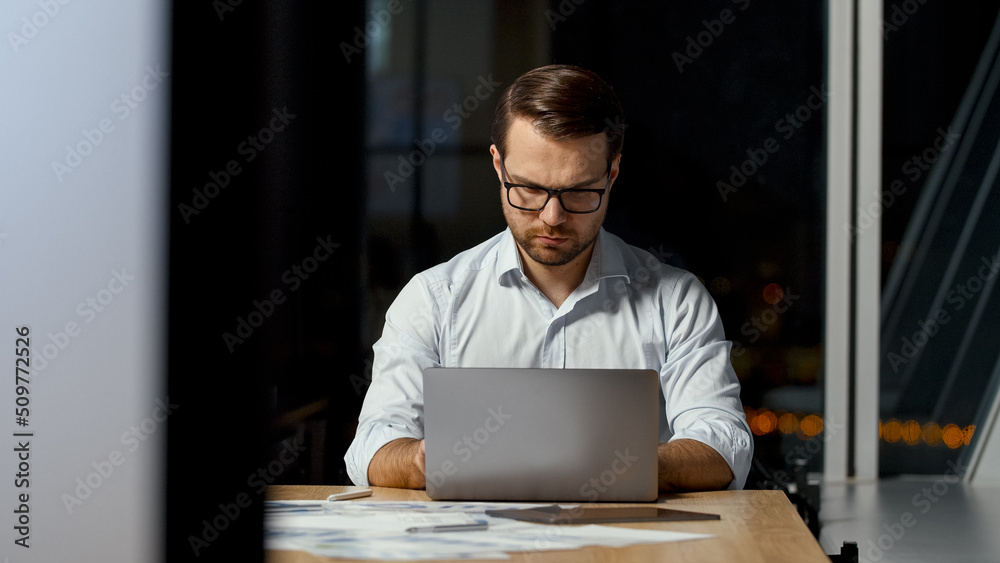 Young ceo typing message on laptop keyboard in office