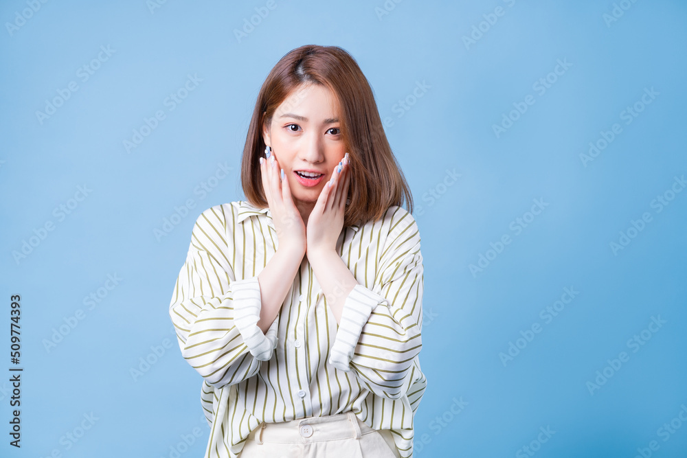 Fototapeta premium Image of young Asian girl posing on blue background