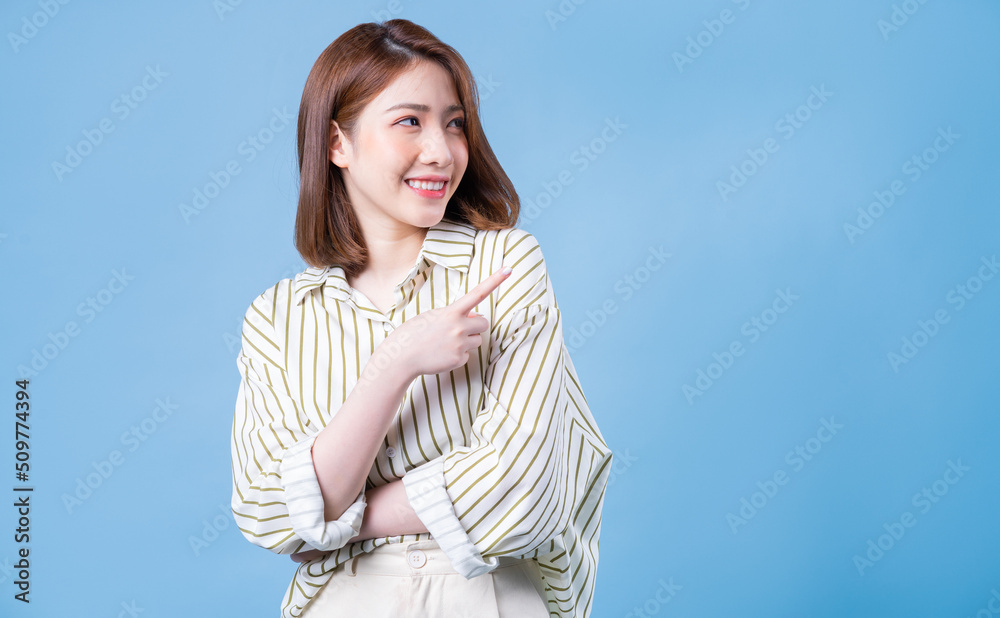 Image of young Asian girl posing on blue background Image of young Asian girl posing on blue background