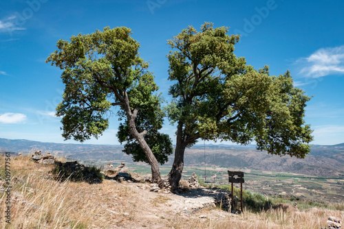 Baloiço do Sobreiro com algumas rochas e pequenas pirâmides de pequenas pedras em Castedo, Torre de Moncorvo, Portugal photo