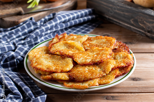 Photography Homemade traditional fried potato pancakes (latke for Hanukkah) served with sour cream and greens on dish