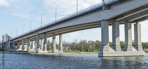 Fototapeta Naklejka Na Ścianę i Meble -  Support pillars of highway bridge over river. Industrial background