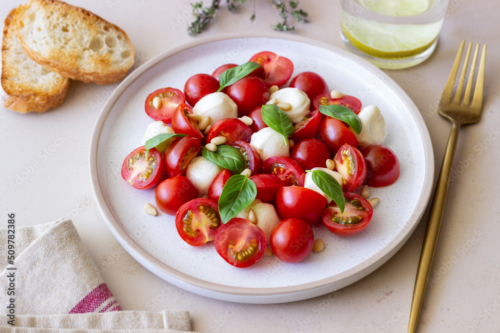 Salad with mozzarella, tomatoes, nuts and basil. Healthy eating. Vegetarian food. Diet.