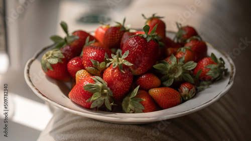 Strawberries on a plate. First summer harvest of strawberries. Fresh ripe strawberries background.