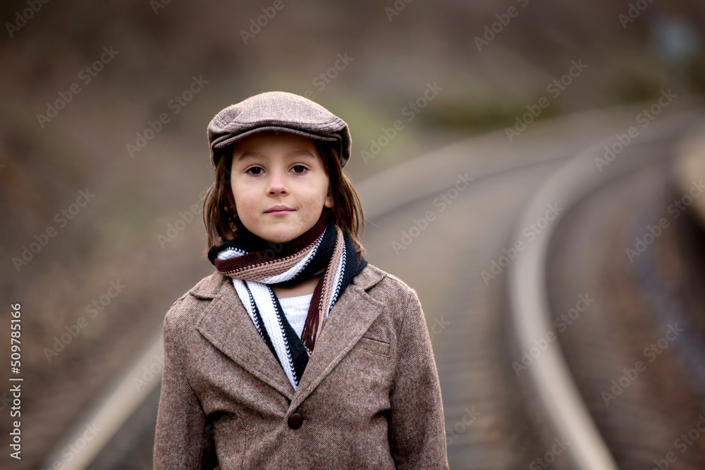 Adorable boy on a railway station, waiting for the train Adorable boy on a railway station, waiting for the train