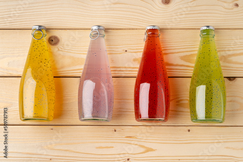 Foto Juice bottles on wooden background flat lay