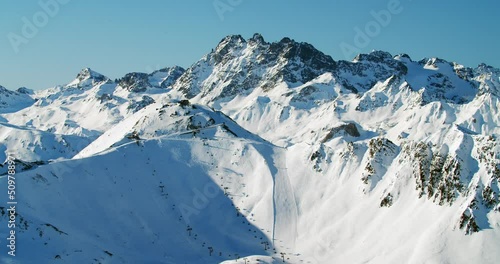 High alpine ski resort panorama view with big ski slopes and moder ski lifts in the austrian alps. Huge summit peaks with fresh snow and beautiful light above 3000 meter sealevel. 4K photo
