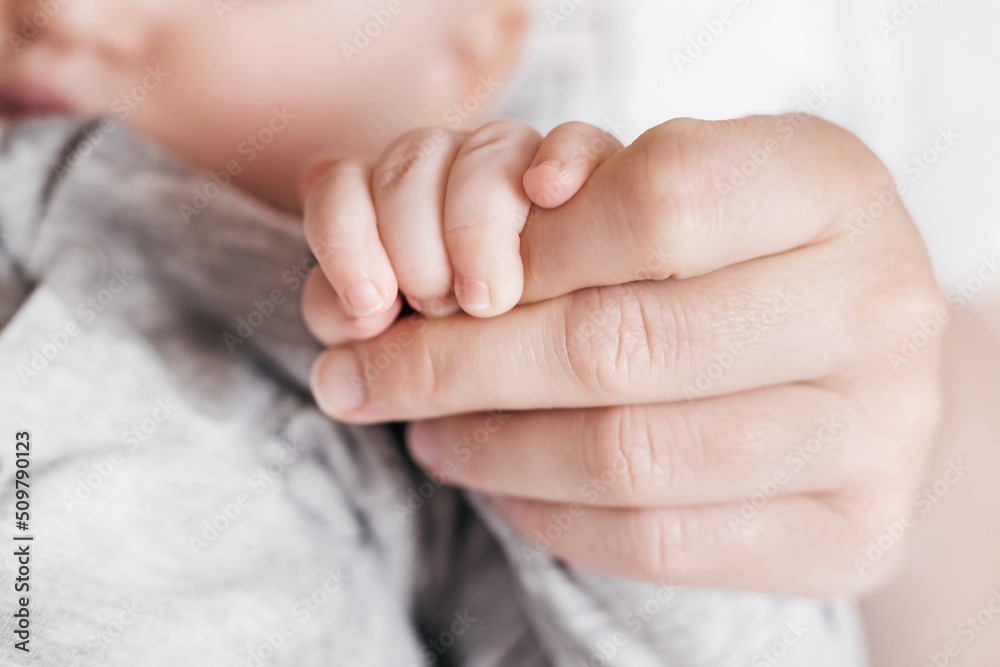 Hand of sleeping baby in the hand of mother. Newborn baby with mom. Motherhood care and baby care Hand of sleeping baby in the hand of mother. Newborn baby with mom. Motherhood care and baby care