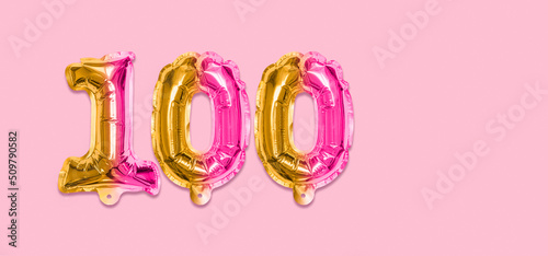 Rainbow foil balloon number, digit one hundred on a pink background. Birthday greeting card with inscription 100. Anniversary concept. Numerical digit. Celebration event, template. Banner