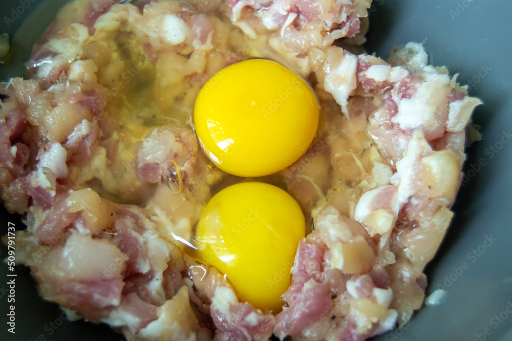 two eggs lie on minced pork. preparation of stuffing for dumplings. stuffing for dumplings. Horizontal image. two eggs lie on minced pork. preparation of stuffing for dumplings. stuffing for dumplings. Horizontal image.