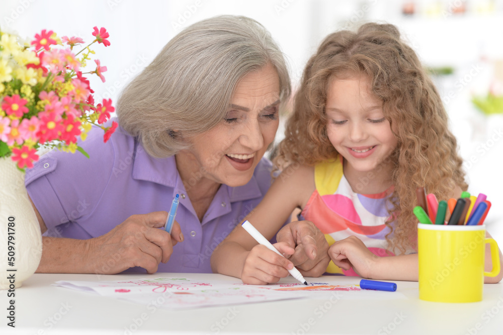 Portrait of a cute little girl drawing with her grandmother Portrait of a cute little girl drawing with her grandmother