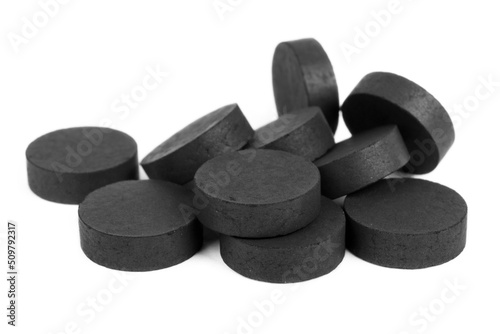 Fotografía Tablets of black activated charcoal on a white background, help with poisoning and toxins