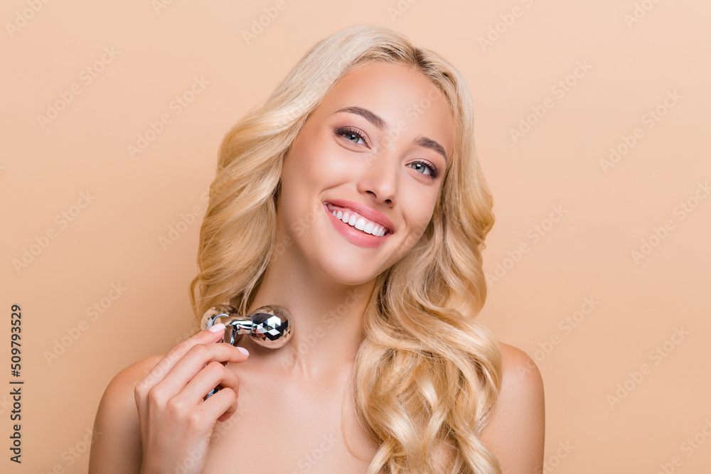 Photo of amazing adorable woman use derma roller on neck wrinkles correction isolated on beige color background Photo of amazing adorable woman use derma roller on neck wrinkles correction isolated on beige color background