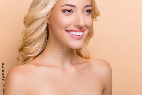 Cropped view portrait of attractive cheerful wavy-haired woman flawless pore harmony isolated over beige pastel color background