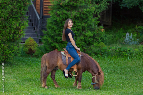 woman riding a pony on the lawn © zokov_111
