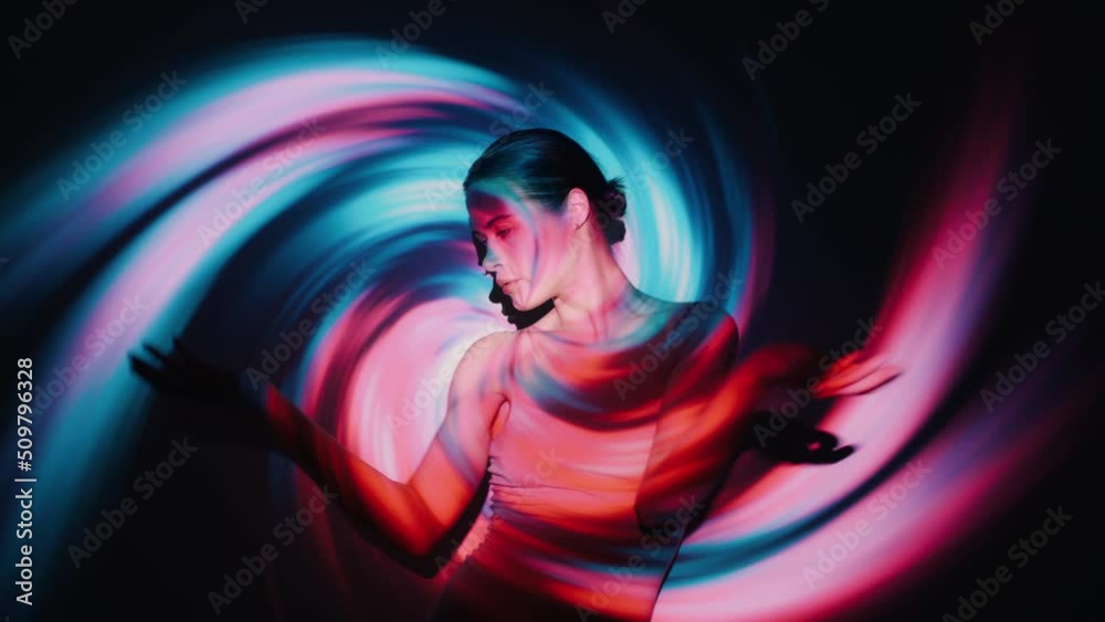 Handsome young female model in flesh color bodysuit dancing seductively moves making expressive movements with her arms and body overlay hypnotic spiral swirl twirl neon colorful animated background Handsome young female model in flesh color bodysuit dancing seductively moves making expressive movements with her arms and body overlay hypnotic spiral swirl twirl neon colorful animated background
