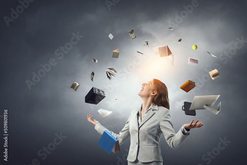 Young pretty businesswoman juggling with business items