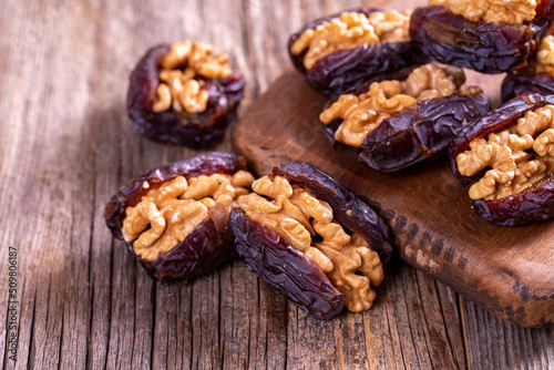 Walnut-stuffed dates on a wood floor. Close-up. Arabian luxury for special occasions such as Ramadan and Eid holidays. local name cevizli hurma