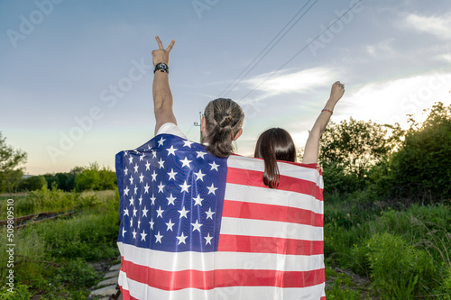 Back view of man and woman holding american flag