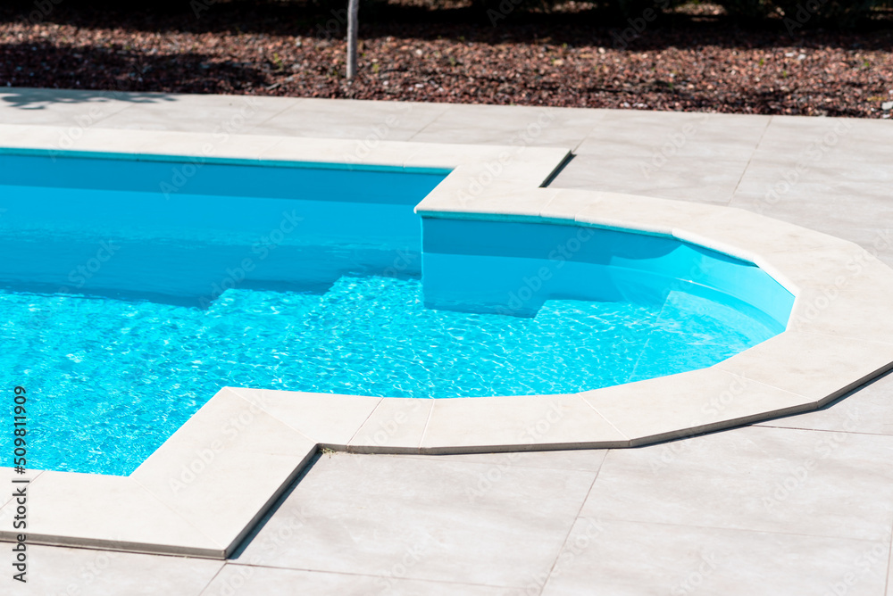 Clear blue water in the pool. Side view. Relax in the backyard of a country house