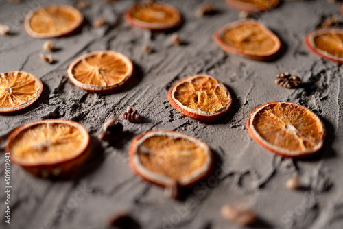 Dried lemons lined up on a tumbled gray background.