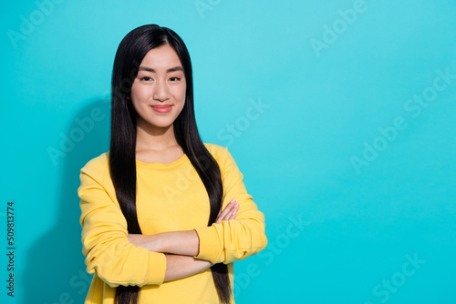 Photo of charming sweet woman wear yellow pullover arms crossed empty space isolated teal color background