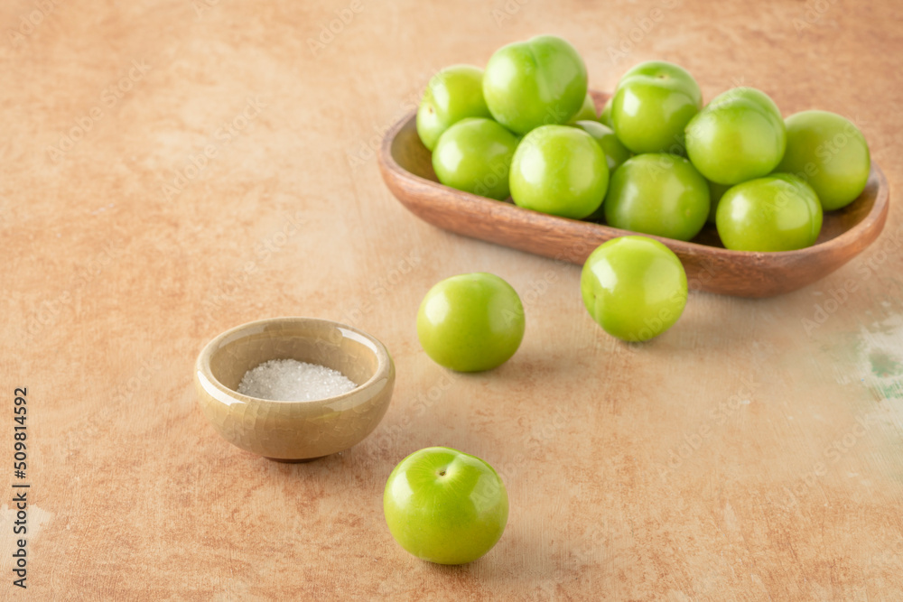 side view ripe green plum fruits served with salt on table