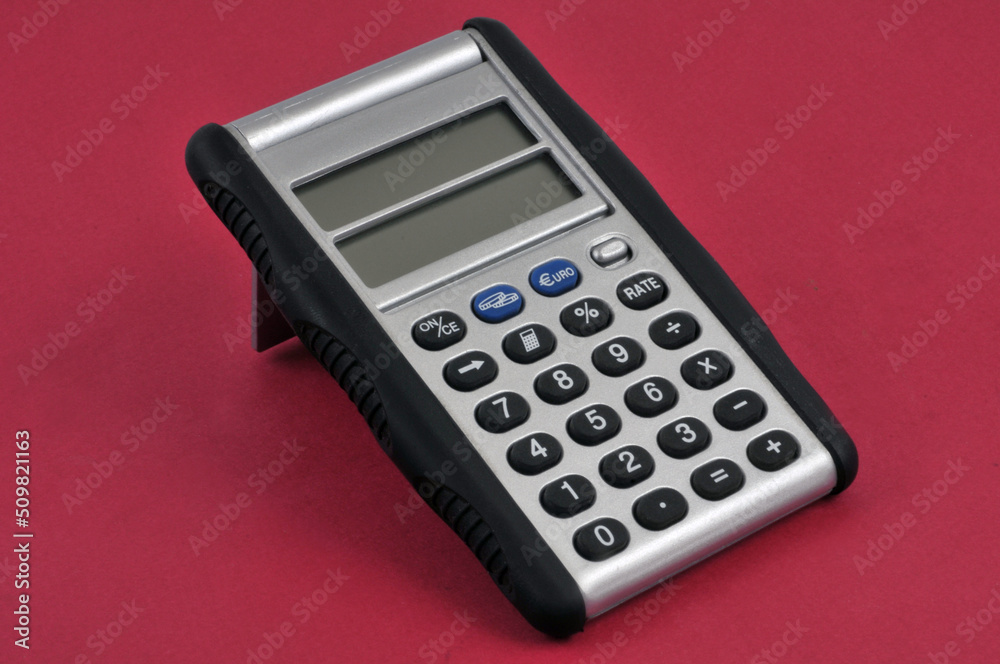 Calculatrice avec un double écran en gros plan sur fond rouge Calculatrice avec un double écran en gros plan sur fond rouge