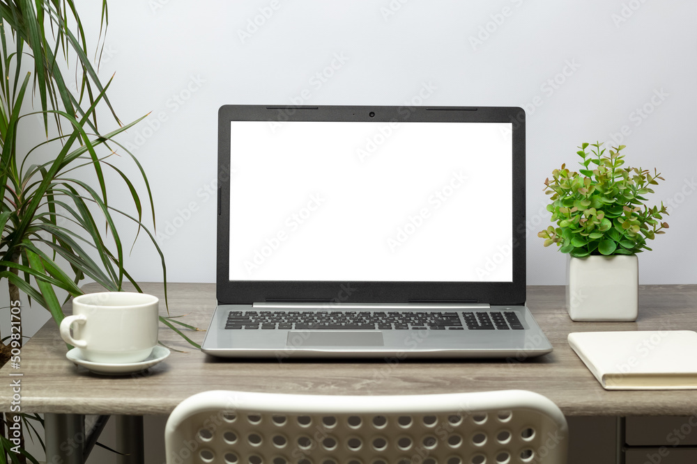 Work desk with laptop with white blank screen.