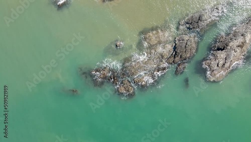 Aerial top view of seascape with wave on rocky and sand beach for travel and relax footage.