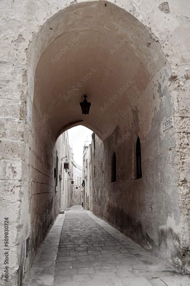 Tunnel with a lantern in a narrow street in the old historical town of Mdina in Malta