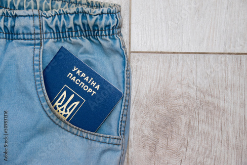 Ukrainian international passport in jeans pocket. Concept of refugees from Ukraine and war